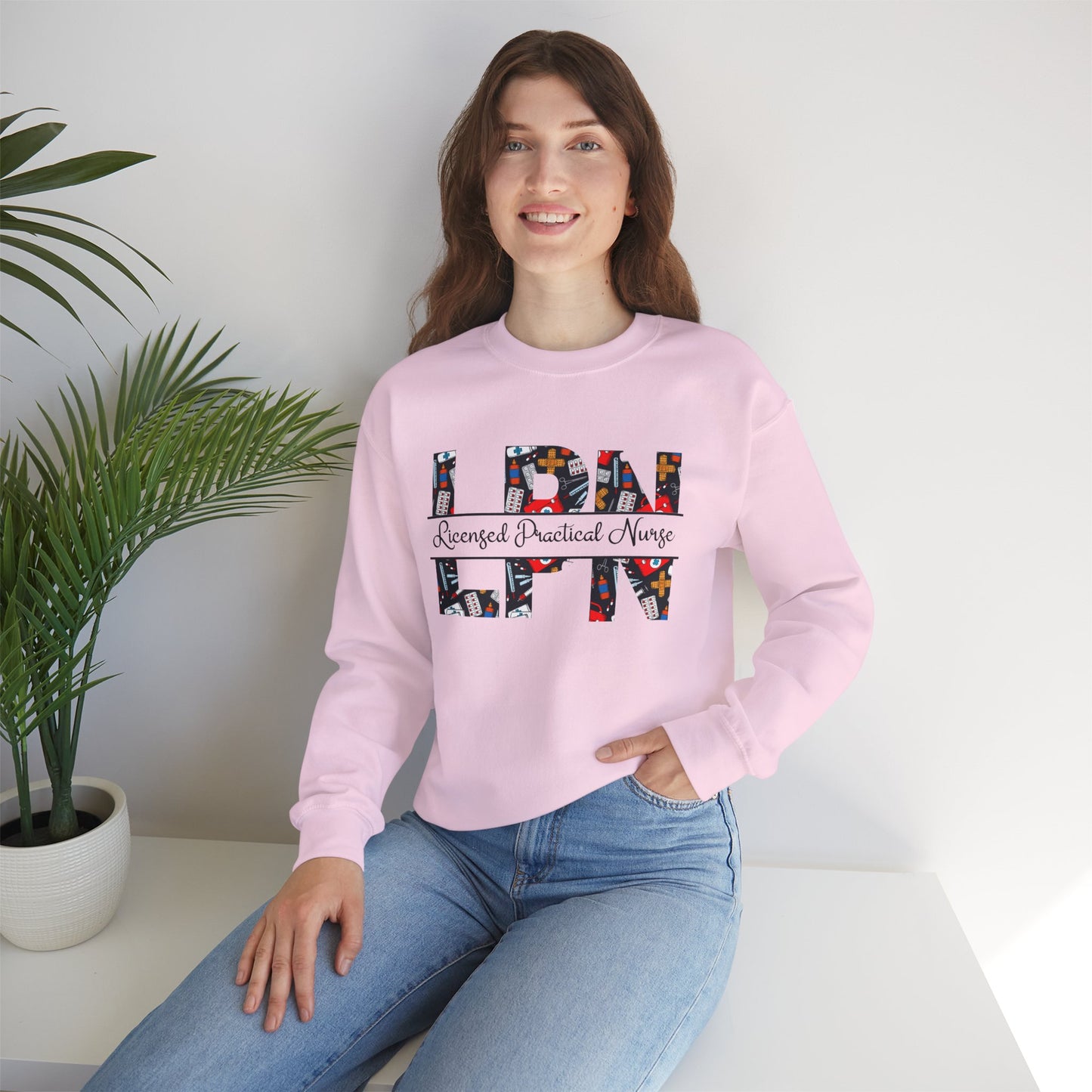 Soft pink Licensed Practical Nurse sweatshirt with bold LPN letters and medical-theme pattern, cozy gift for nurses.