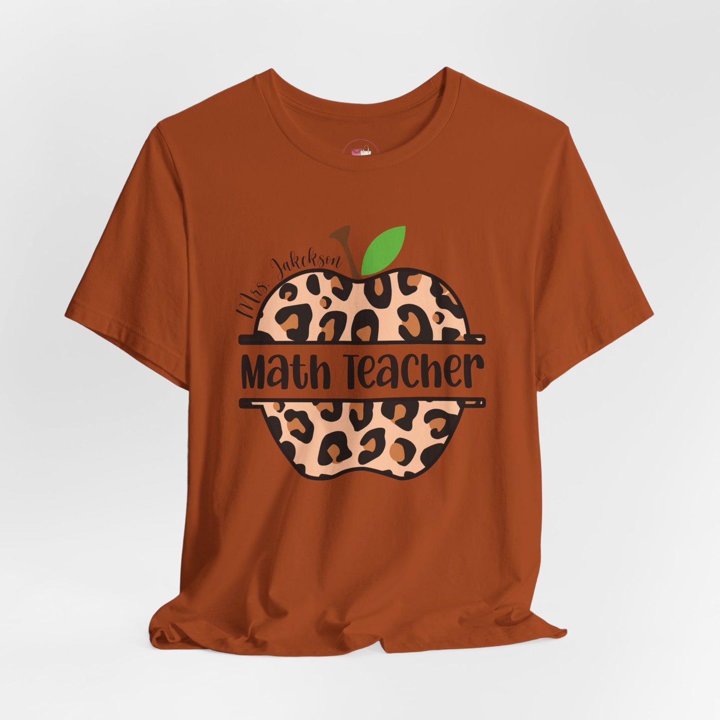 Brown t-shirt with leopard print apple graphic and 'Math Teacher' text on a white background