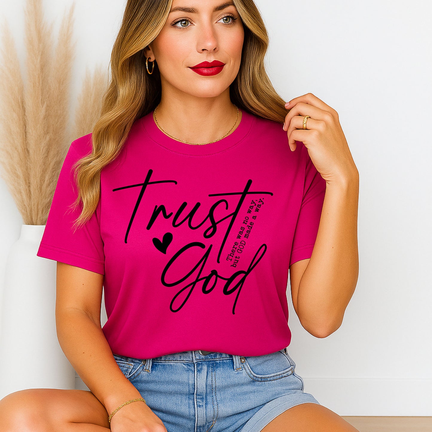 Woman wearing a pink t-shirt with 'Trust God' text