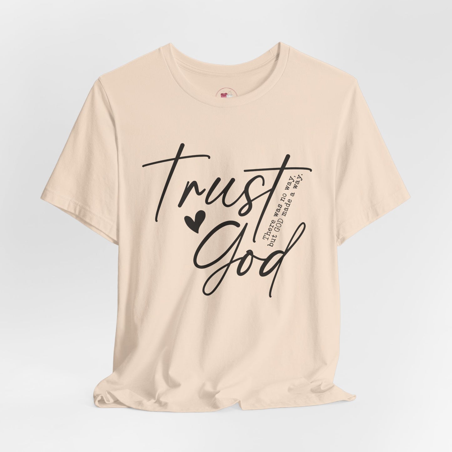 Beige t-shirt with 'Trust God' text on a light gray background
