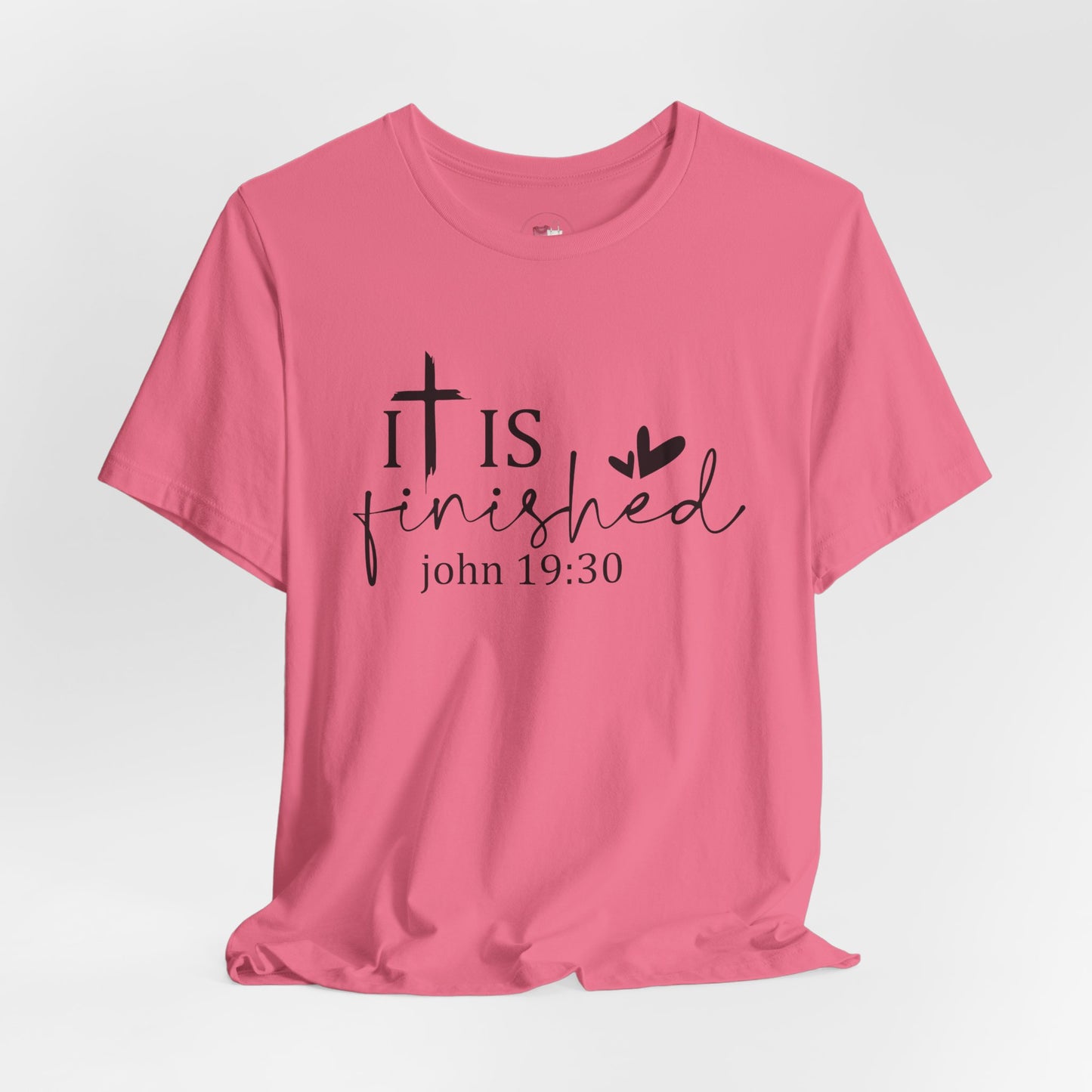 Pink t-shirt with 'It is finished' text and cross design on a white background, Bible scripture