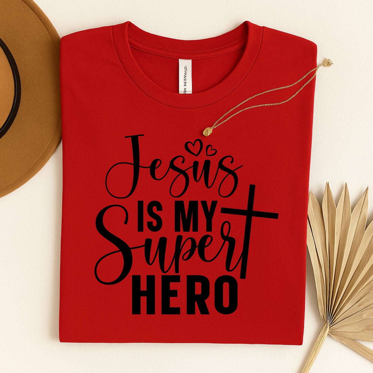 Red t-shirt with 'Jesus is my Super Hero' text on a light background. Christian based