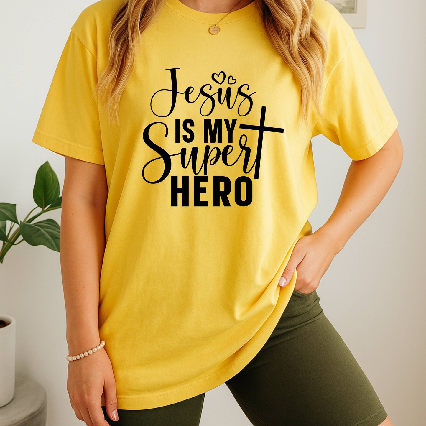 Person wearing a yellow t-shirt with 'Jesus is my Super Hero' text.