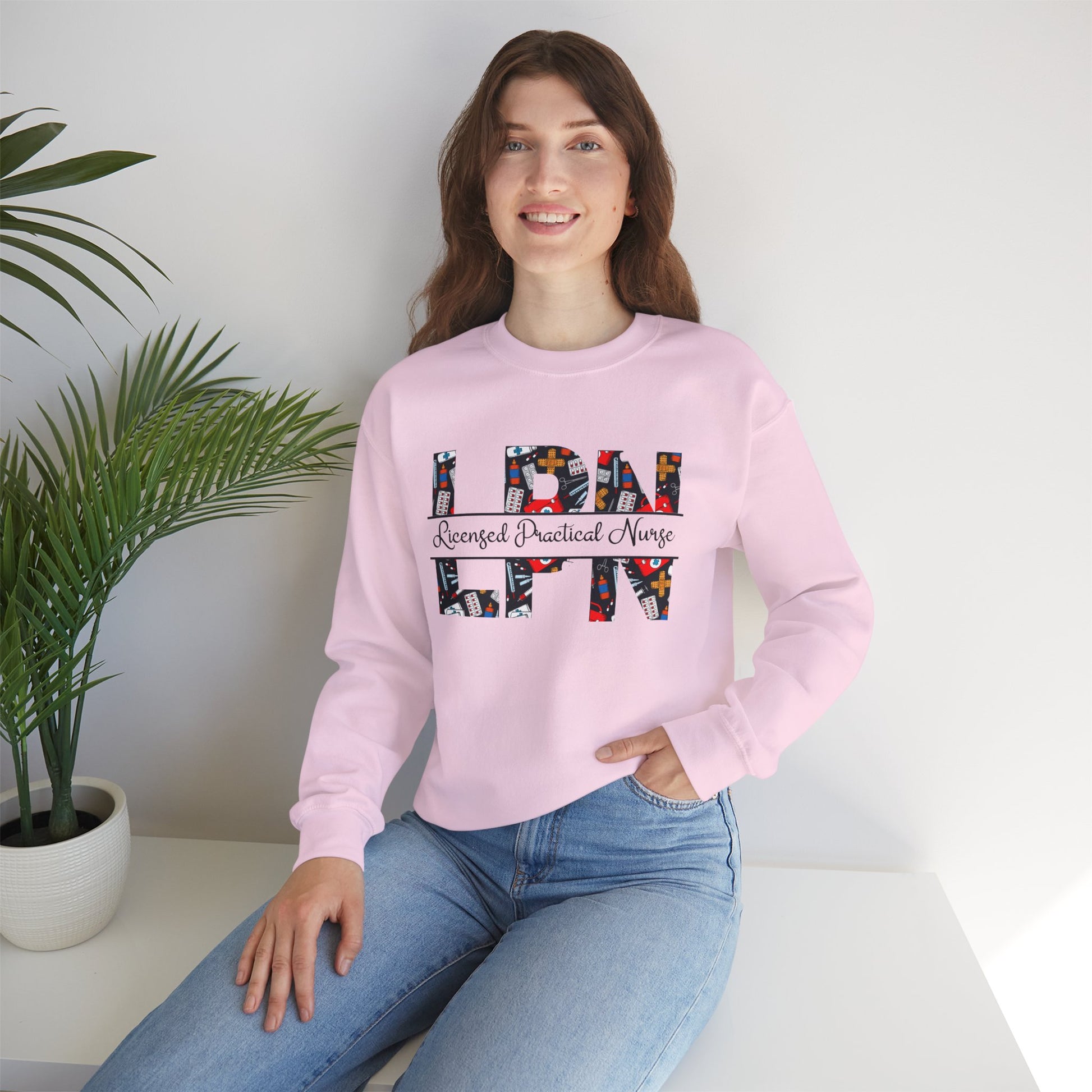 Soft pink Licensed Practical Nurse sweatshirt with bold LPN letters and medical-theme pattern, cozy gift for nurses. 