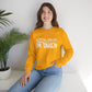 Woman wearing a yellow sweatshirt with 'sorry guys I'm taken' text, sitting indoors.