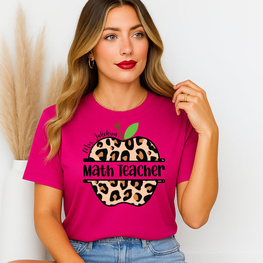 Woman wearing a pink t-shirt with a leopard print apple design and 'Math Teacher' text.