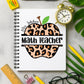 Notebook with leopard print apple design labeled 'Math Teacher' on a desk with stationery items.