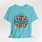 Light blue t-shirt with leopard print apple graphic and text on a white background