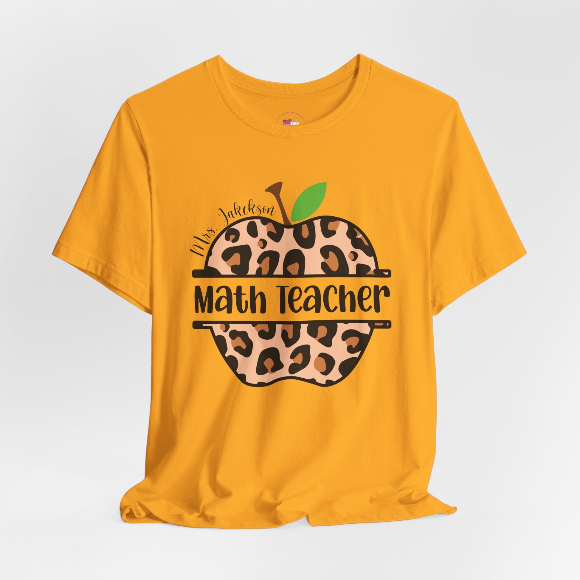 Yellow t-shirt with leopard print apple design and 'Math Teacher' text on a white background