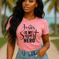 Christian based pink t-shirt with 'Jesus is my super hero' text outdoors.