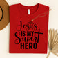 Red t-shirt with 'Jesus is my Super Hero' text on a light background. Christian based